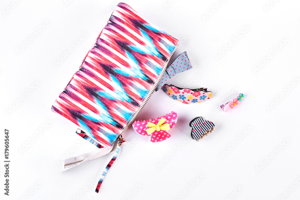 Hair clips next to opened cosmetics bag. Hair pins and fashion bag