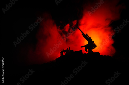 An anti-aircraft cannon and Military silhouettes fighting scene on war fog sky background, World War Soldiers Silhouettes Below Cloudy Skyline at sunset. Attack scene.