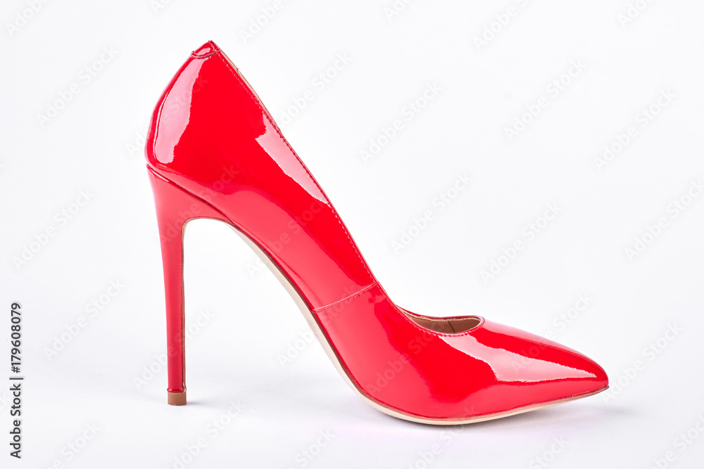 Woman red shoe on white background. Red female shoe on high heel on white background in profile. Woman fashion accessory. Woman red shoe on white background. Red female shoe on high heel on white background in profile. Woman fashion accessory.