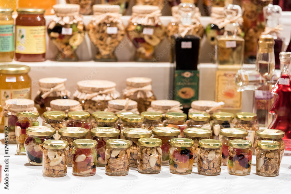 Honey with mixed nuts in jars on open market stall