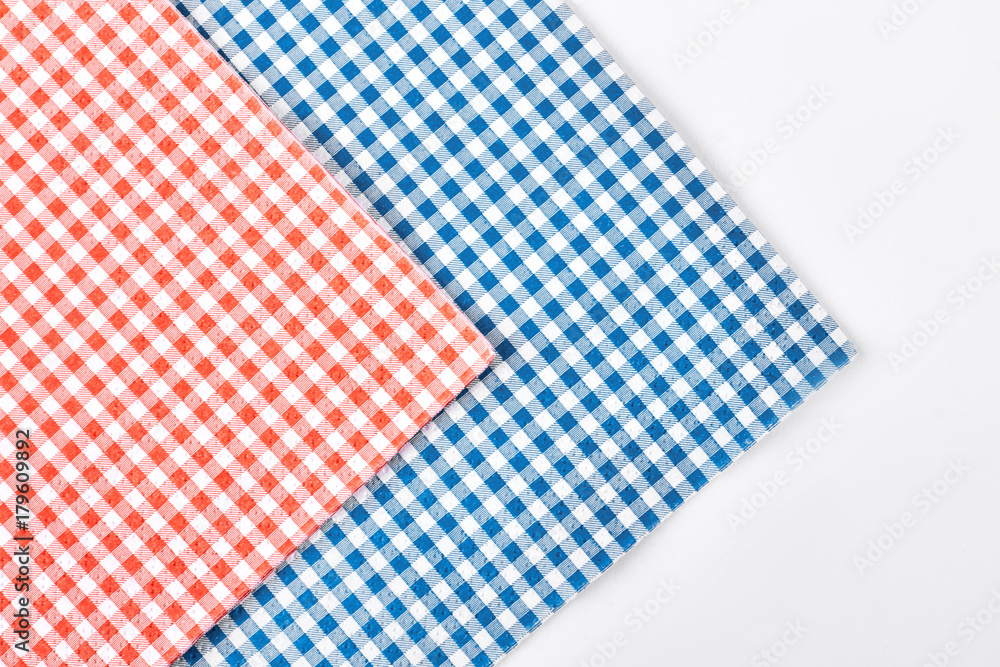 Cloth checkered napkins, white background. Fabric red and blue checkered napkins close up, cropped image.