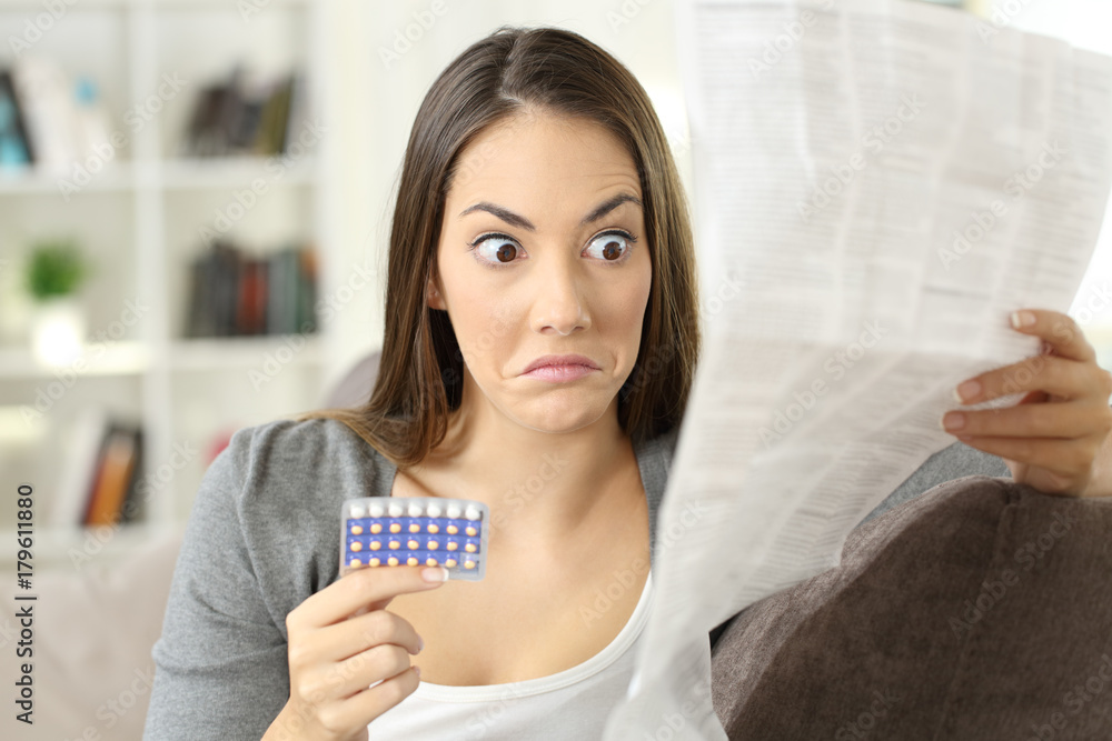 Confused girl reading leaflet of contraceptive pills Confused girl reading leaflet of contraceptive pills