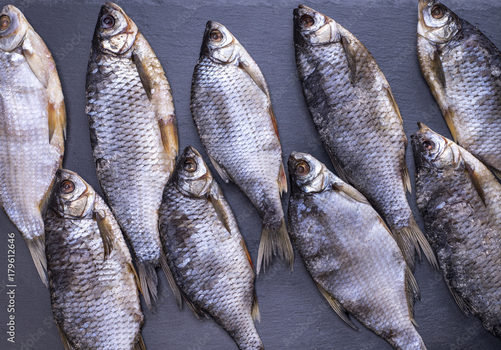 dried fish scam with scales on a black background dried fish scam with scales on a black background