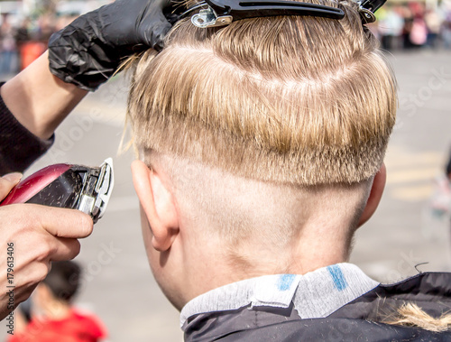 Hairdresser cuts teenager photo