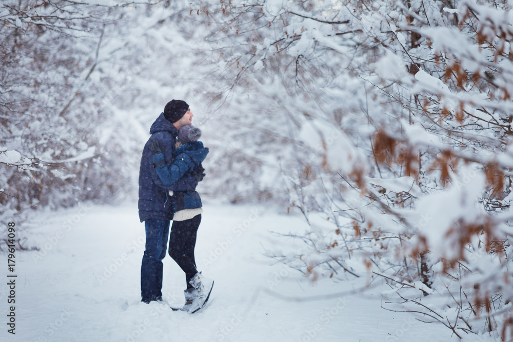 Happy Couple embracing Outdoors in Snow Park. Winter Vacation. Blurred image