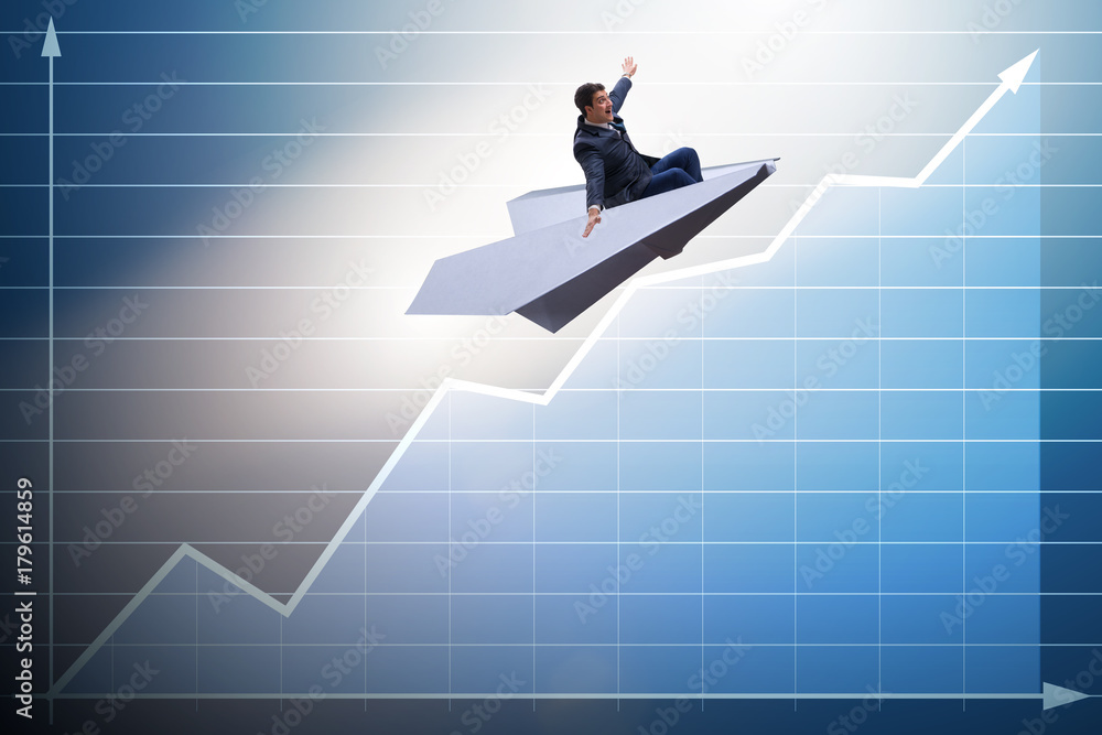Businessman flying on paper plane in business concept Businessman flying on paper plane in business concept