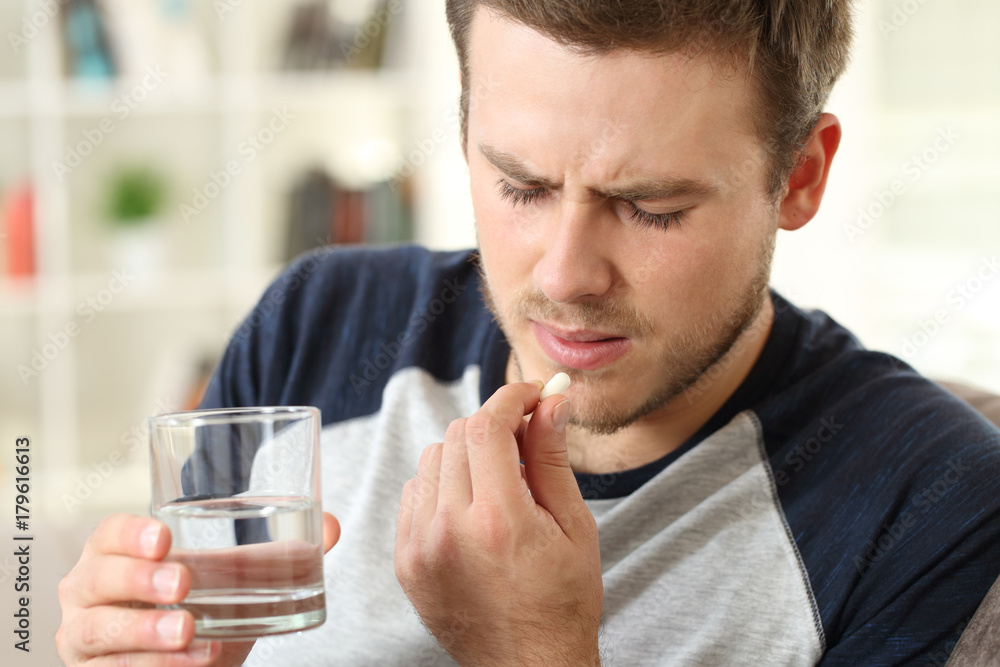 Man suffering taking a pill Man suffering taking a pill