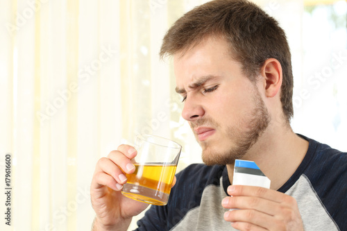 Man drinking a medicine with bad taste