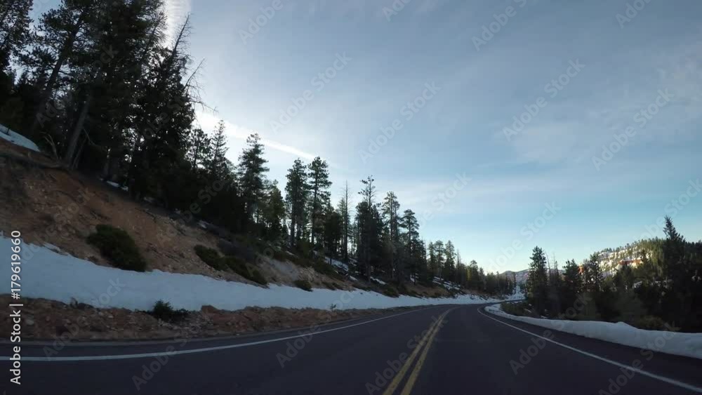Heading Down Hill on Road Through Bryce Canyon with snow on either side Heading Down Hill on Road Through Bryce Canyon with snow on either side