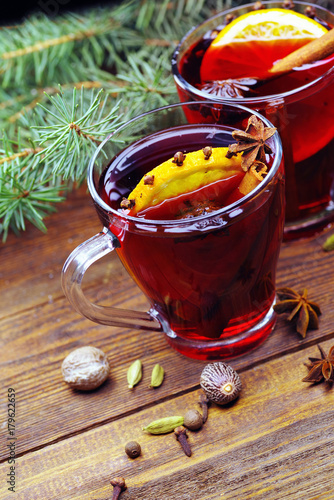 Glass cups of delicious Christmas mulled wine on wooden background, closeup