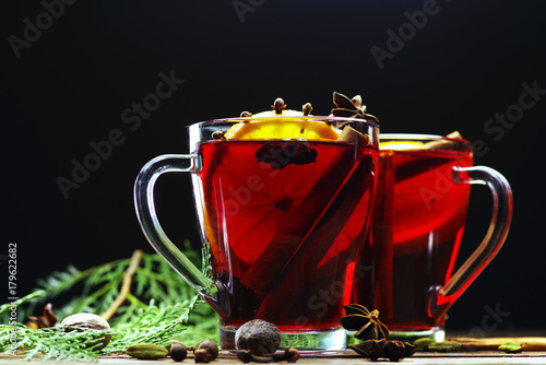 Glass cups of delicious Christmas mulled wine on wooden background, closeup