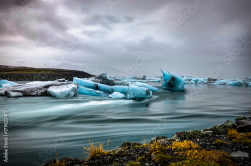 Icebergs floating in Jokulsarlon glacier lake at sunset in Icela photo