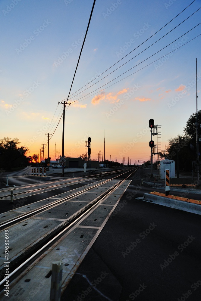 Double-track mainline tracks disappearing into the horizon and dusk as they pass under a series of power lines near Elgin, Illinois. Double-track mainline tracks disappearing into the horizon and dusk as they pass under a series of power lines near Elgin, Illinois.