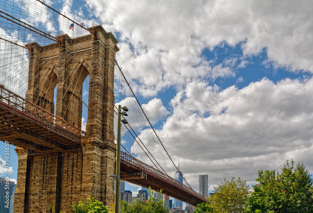 Fototapeta premium Brooklyn Bridge z dolną panoramą Manhattanu w tle.