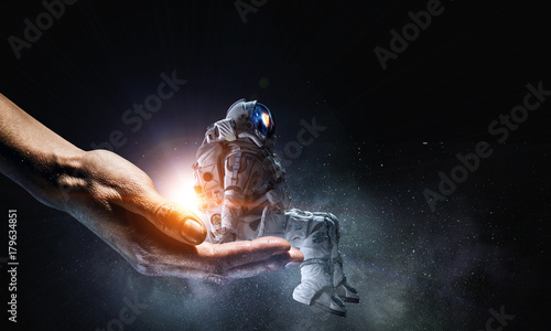 Spaceman in male hand. Mixed media