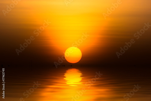 Big sunrise in golden hour at the lake. © noppharat
