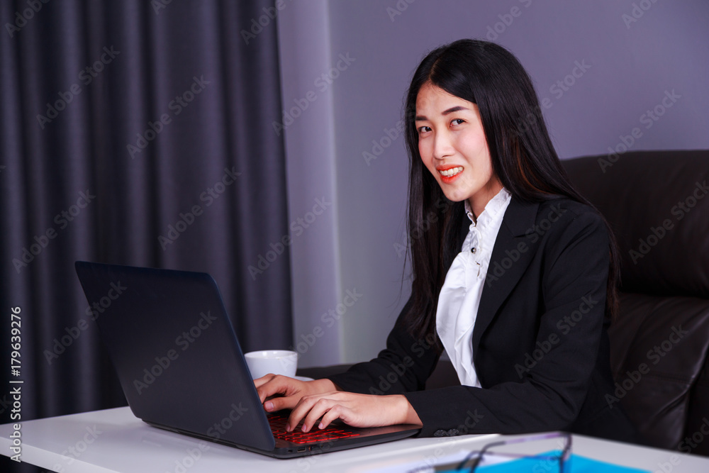 business woman sitting at the desk and using laptop computer for her work business woman sitting at the desk and using laptop computer for her work
