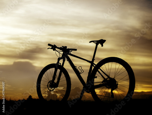 Silhouette bicycle on sunset background.