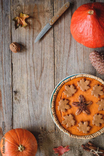 Pumpkin pie, pumpkins, knife and maple leaf on old wooden table. Copy space for text. Fall comfort food, Thanksgiving day food concept