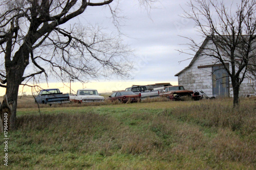Old cars next to old farm