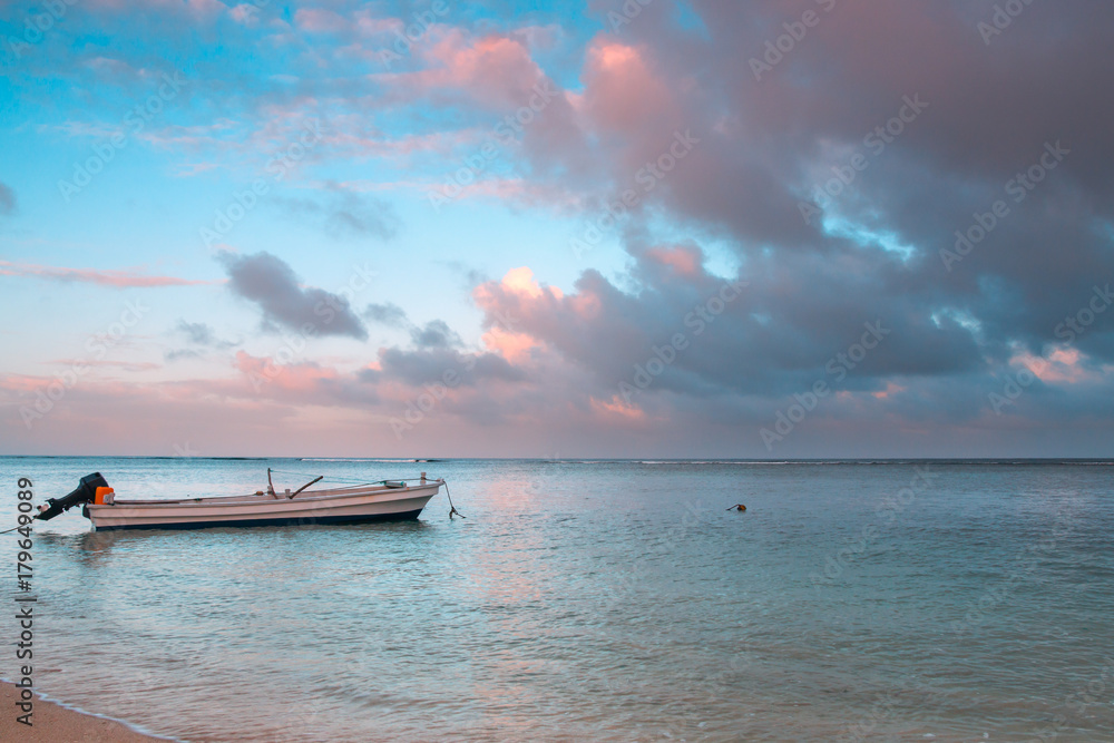 Little boat anckored  on a beach at sunrise, Tonga