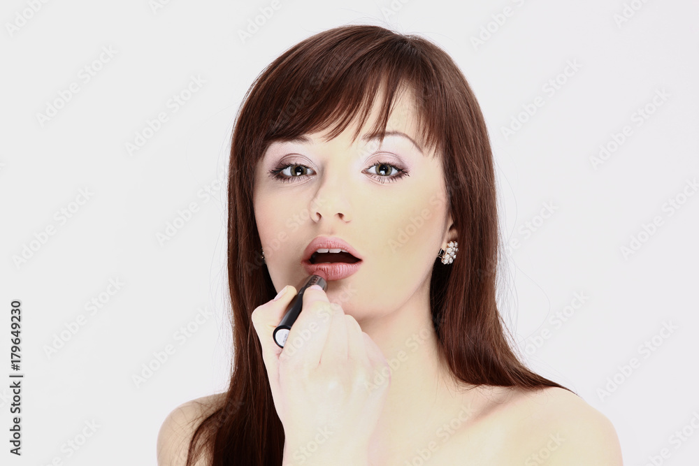 closeup. a young woman uses lip gloss closeup. a young woman uses lip gloss