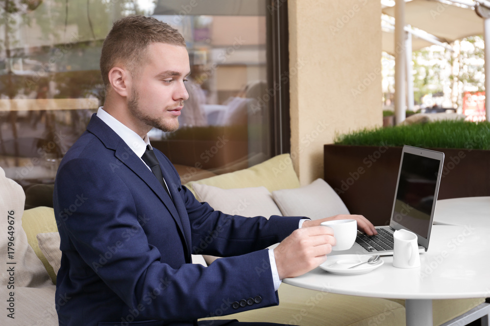 Handsome businessman working with laptop in street cafe Handsome businessman working with laptop in street cafe