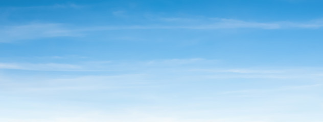 An aerial background view from of clear blue skies and white faint clouds - panoramic web banner