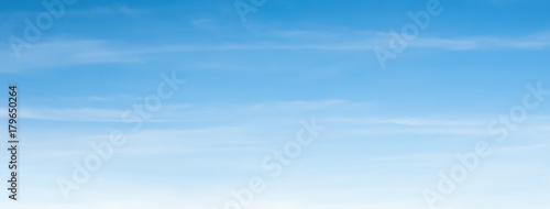 An aerial background view from of clear blue skies and white faint clouds - panoramic web banner