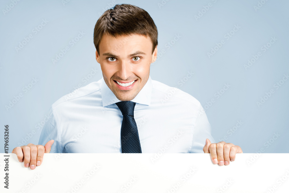 Business man showing blank signboard, over blue