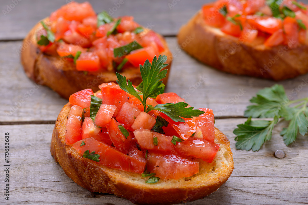 Bruschetta with tomatoes on wooden table