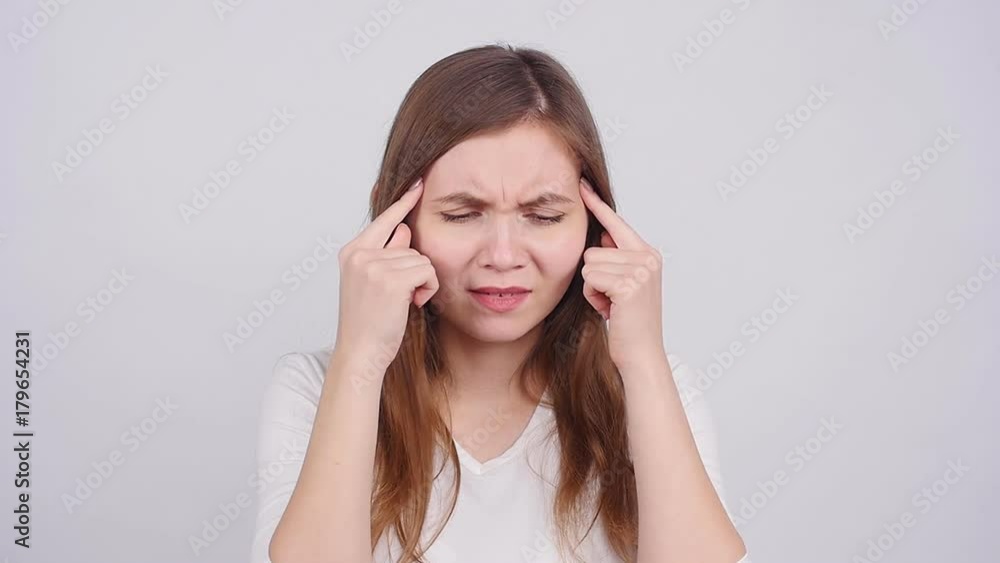 Woman with a headache holding head on a white background Woman with a headache holding head on a white background