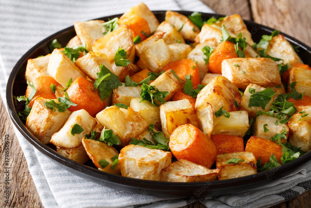 Healthy food: baked celery root and carrots close-up on a table. horizontal Healthy food: baked celery root and carrots close-up on a table. horizontal
