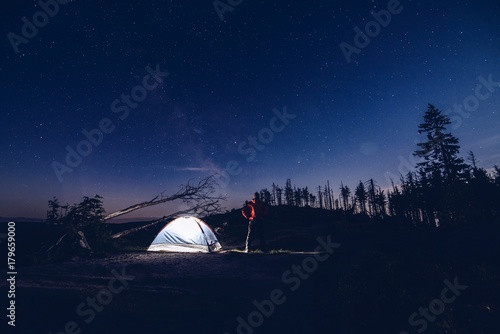 Man tourist at night camp in mountains.