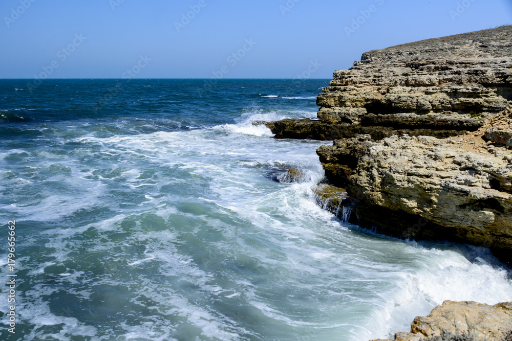 waves break against rocks