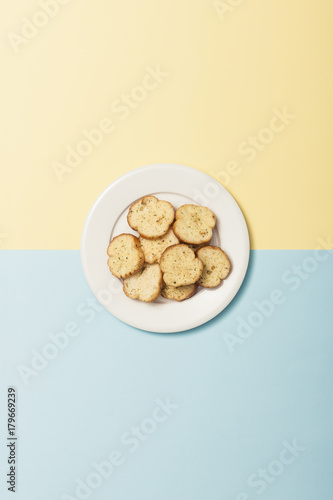 garlic cookies with dish on the color(blue, yellow) paper background.