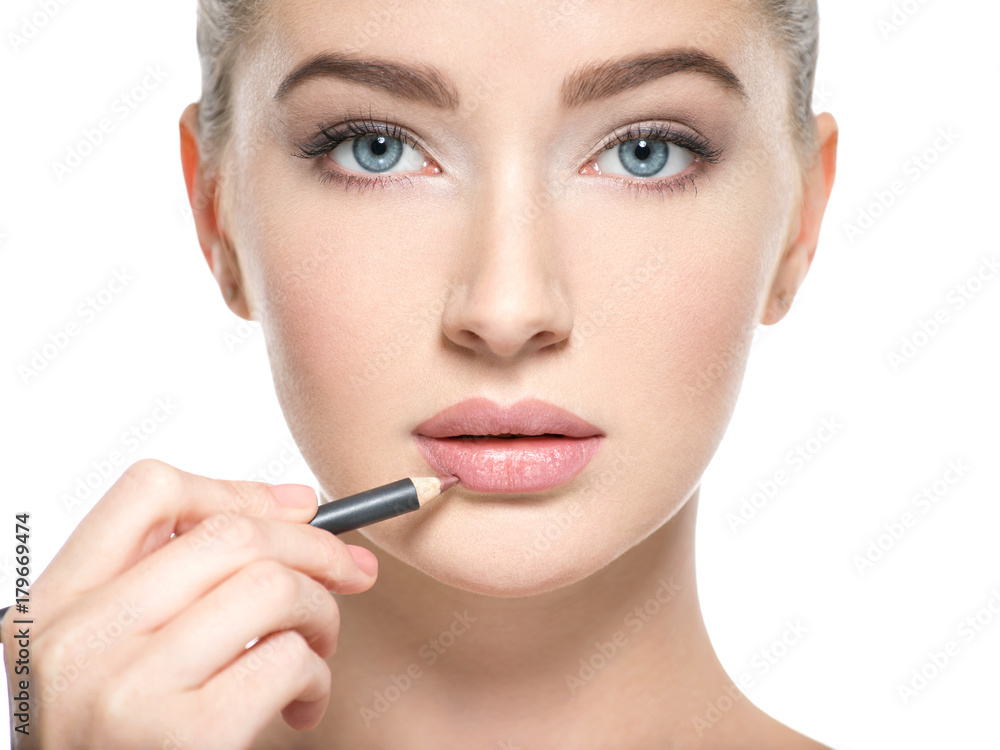  Woman apply lipstick with cosmetic pencil on the lips