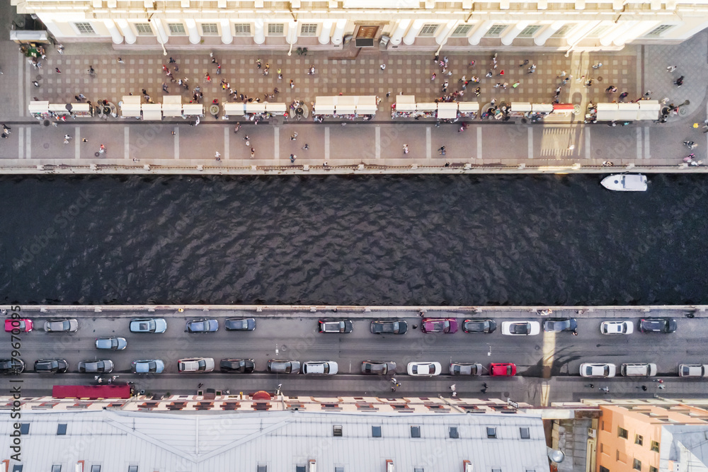 Top view of the people and cars on the banks of the river channel Top view of the people and cars on the banks of the river channel