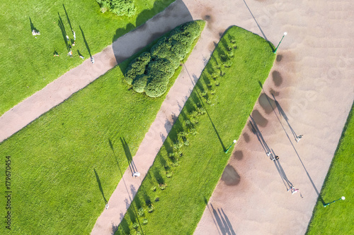 People on the path in a green park, top view photo