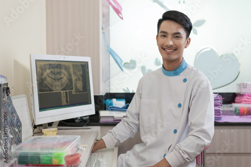 Male dentist crossing armin dental clinic photo