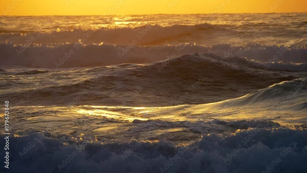 Slow motion shot of sea waves over sunset background Slow motion shot of sea waves over sunset background