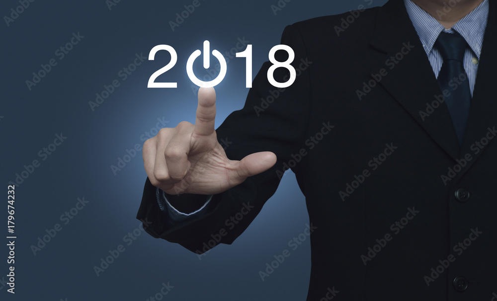 Businessman pressing 2018 start up business icon over blue background, Happy new year concept Businessman pressing 2018 start up business icon over blue background, Happy new year concept
