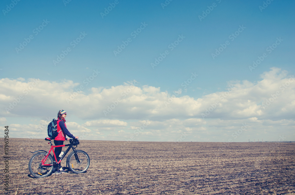 Fototapeta premium girl with a bicycle in the open field