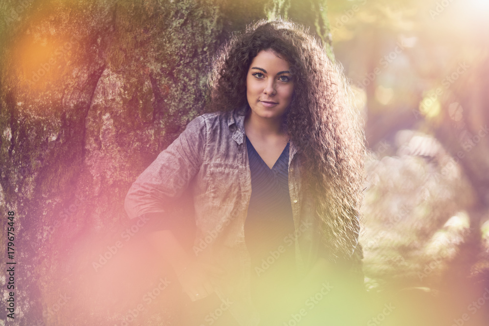 Beautiful Curly woman in the forest, sunlight in the background