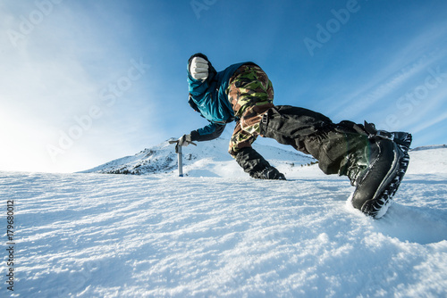 climber with an ice ax climb on the snowy mountain