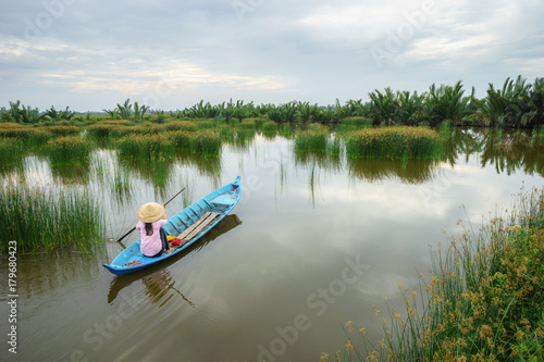 Landscape with rowing boat on rush field in Ca Mau province, Mekong delta, South Vietnam
