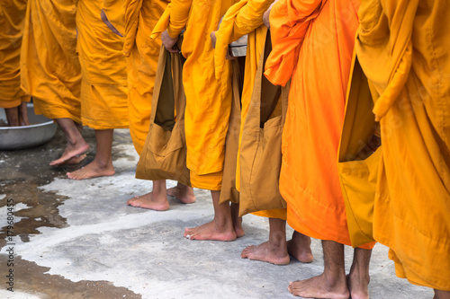 Queue of barefoot monks with foot wash ceremonial in south of Vietnam