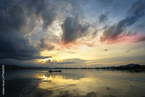 Lake with wooden boat at sunset in Vietnam