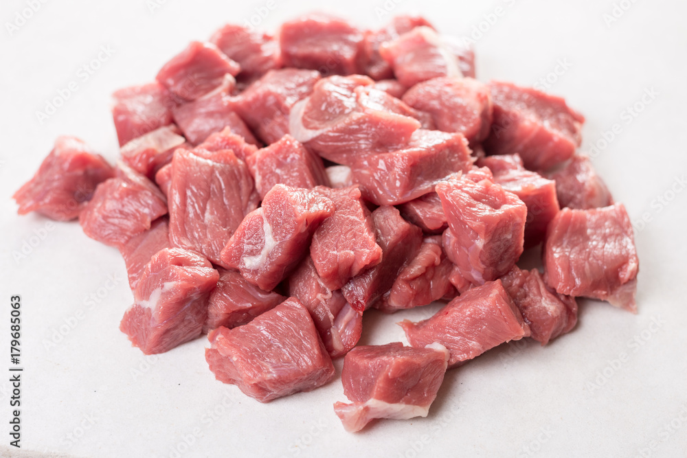 Pile of chopped raw beef steak on the white marble background table Pile of chopped raw beef steak on the white marble background table
