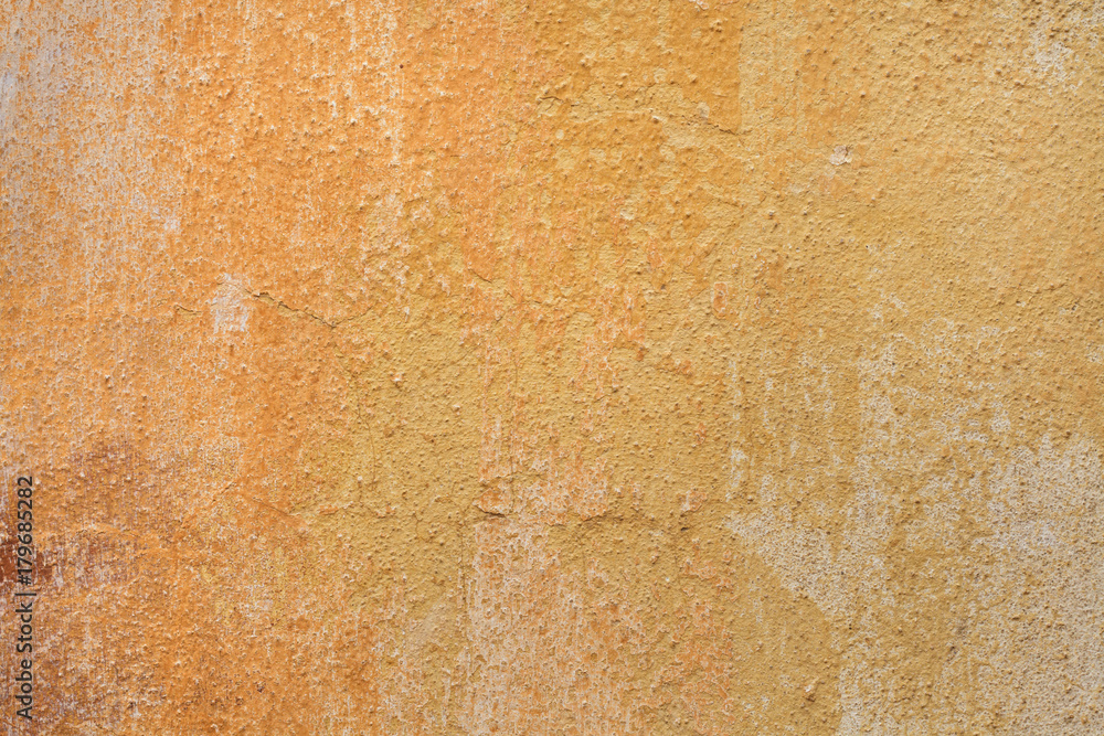 Fototapeta premium Yellow ochre painted stucco wall. Background texture